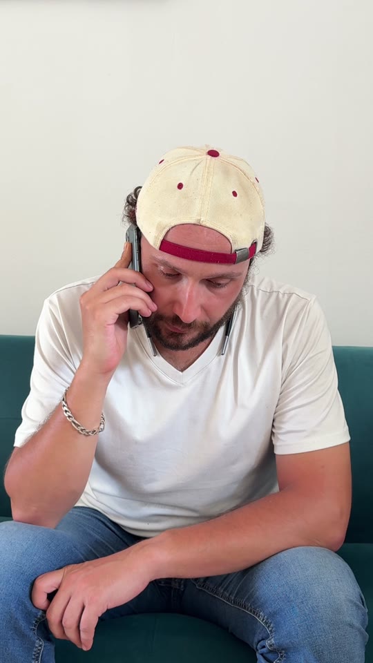 Romain assis au téléphone, incliné vers l’avant